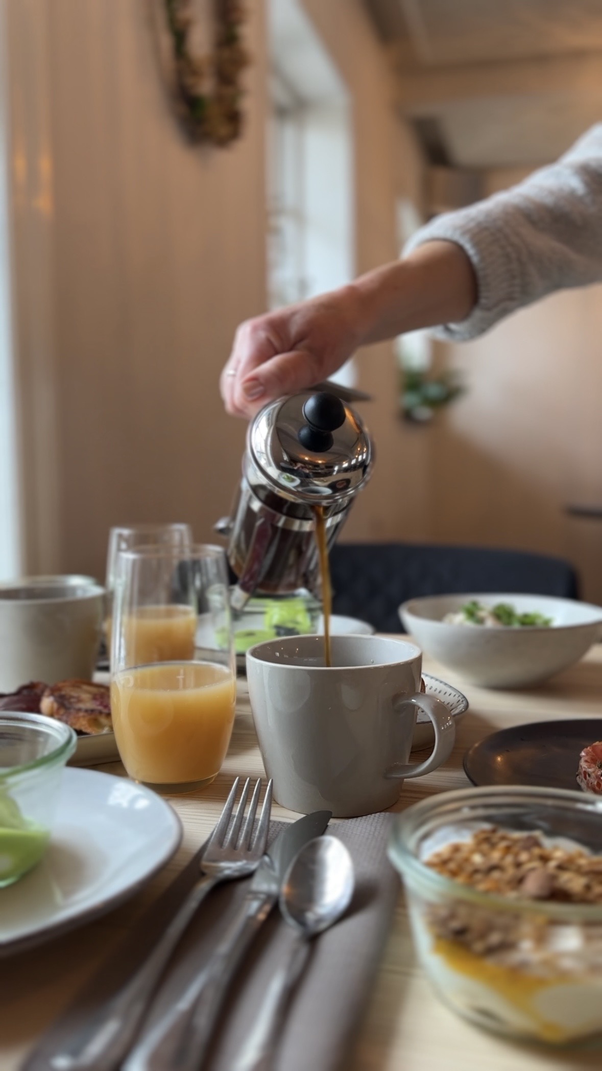 Morgenmad på Gl. Brydegaard. Kaffe hældes i kop, juice i glas, opdækning med mad